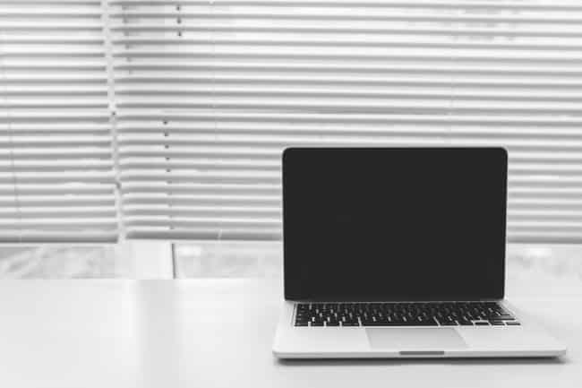 Macbook in front of venetian blinds